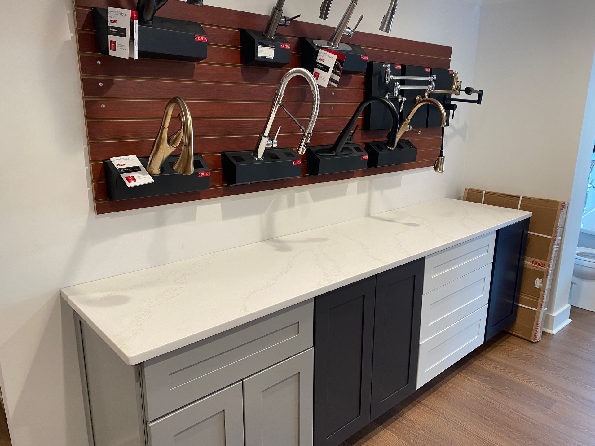 A kitchen counter with a lot of faucets hanging on the wall.
