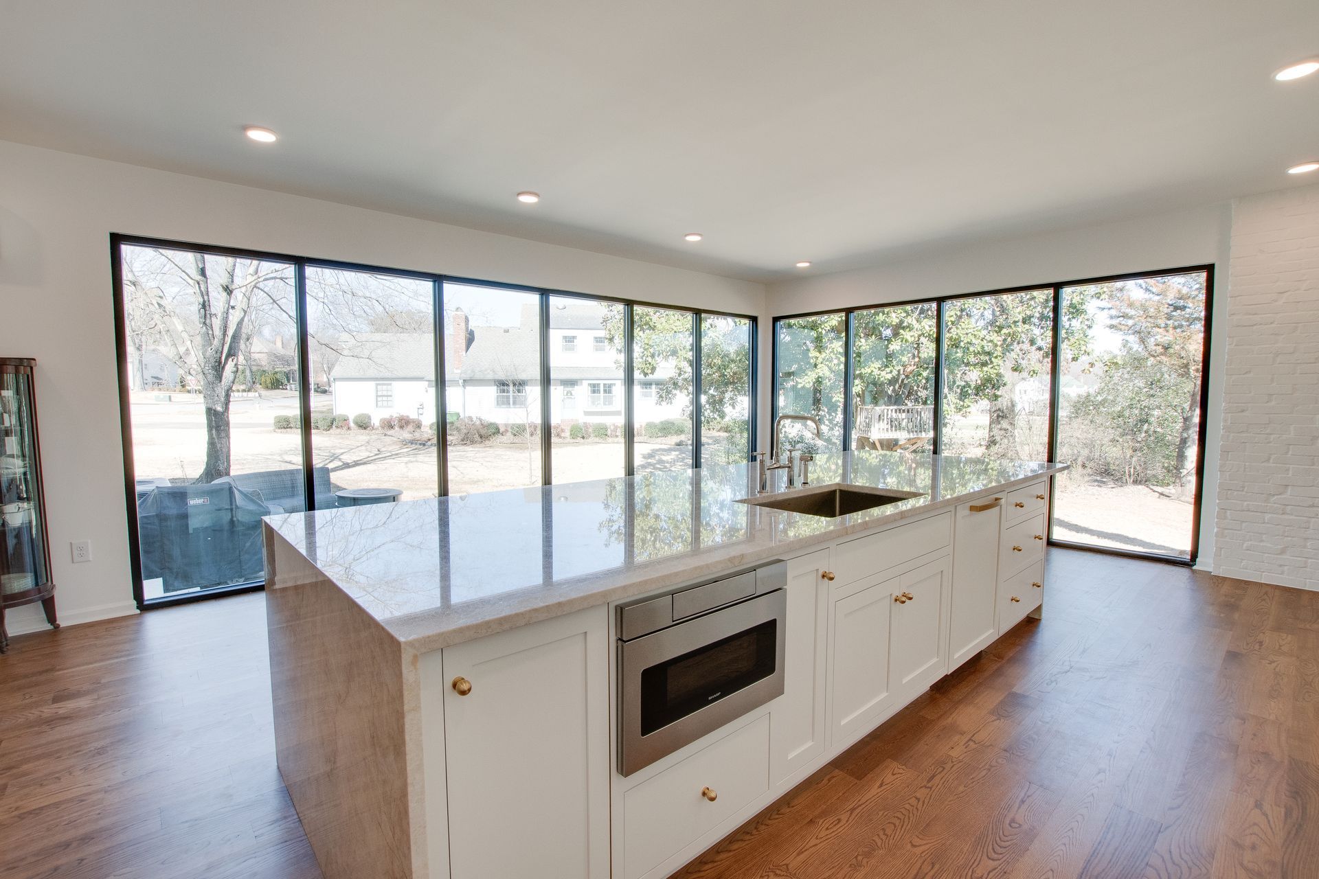 A kitchen with a large island and lots of windows.