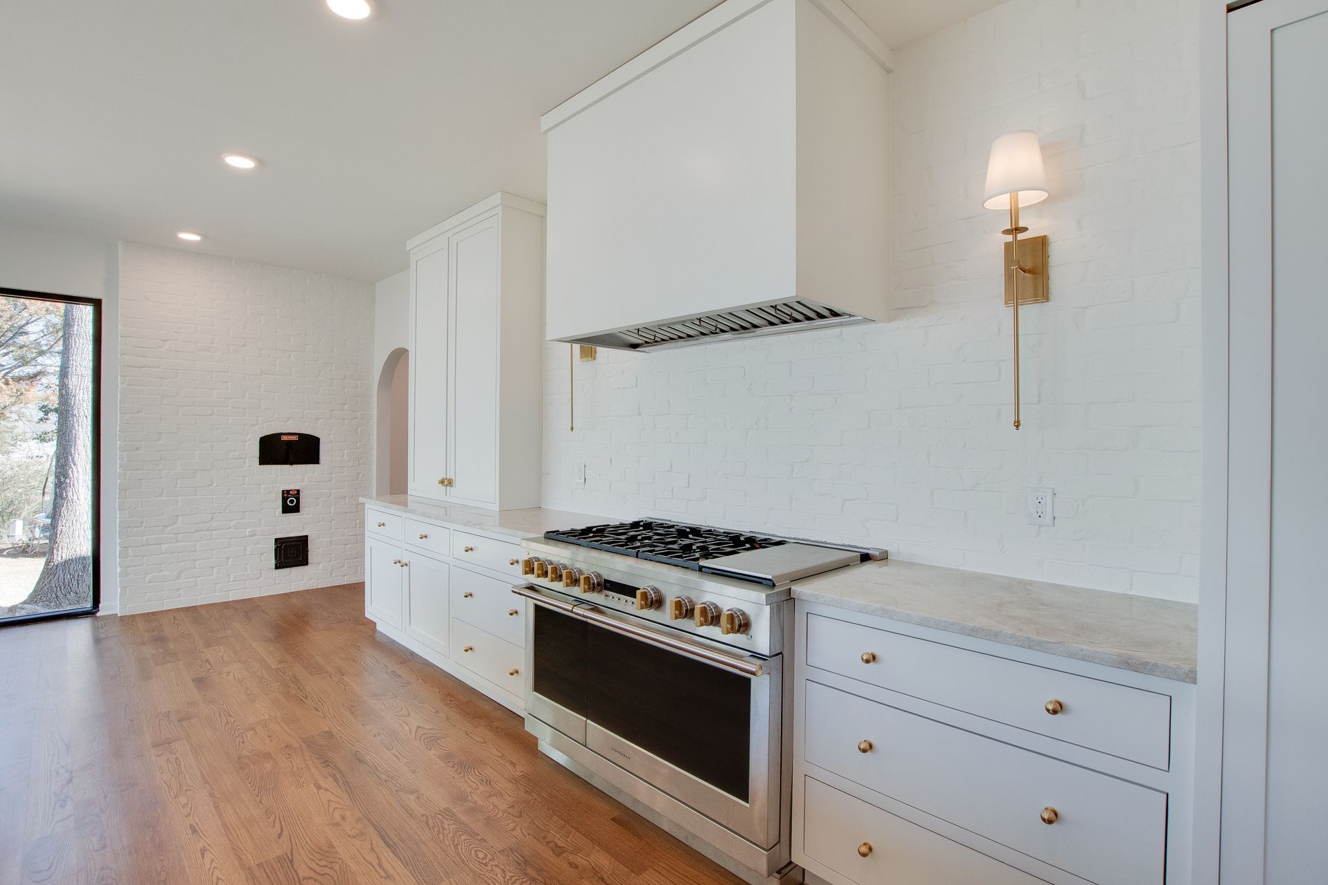 A kitchen with white cabinets and a stove top oven.