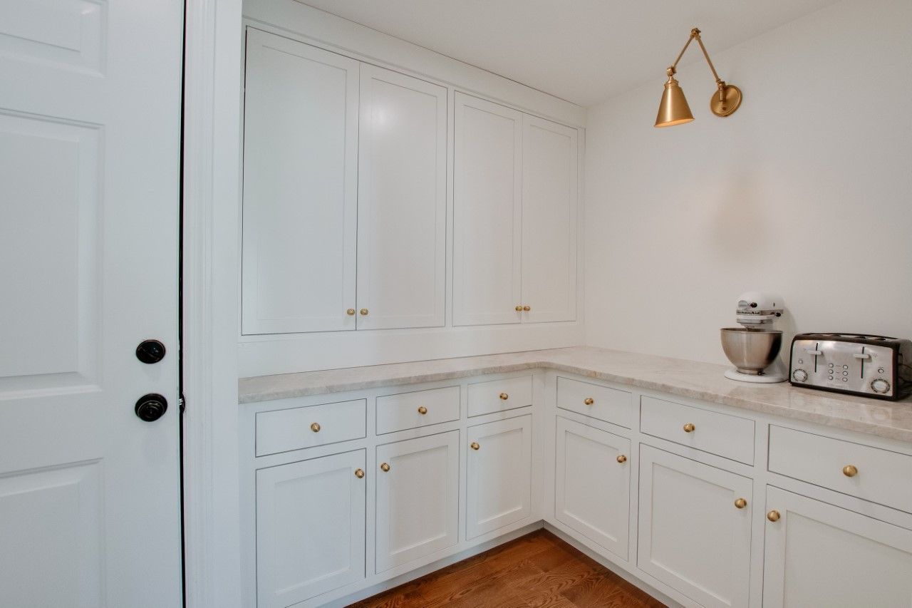 A kitchen with white cabinets and a toaster oven.