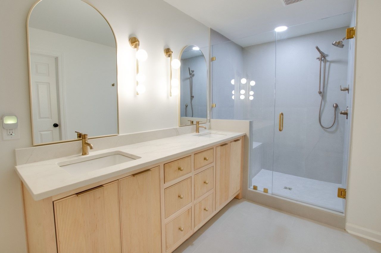 A bathroom with a sink , mirror and shower.