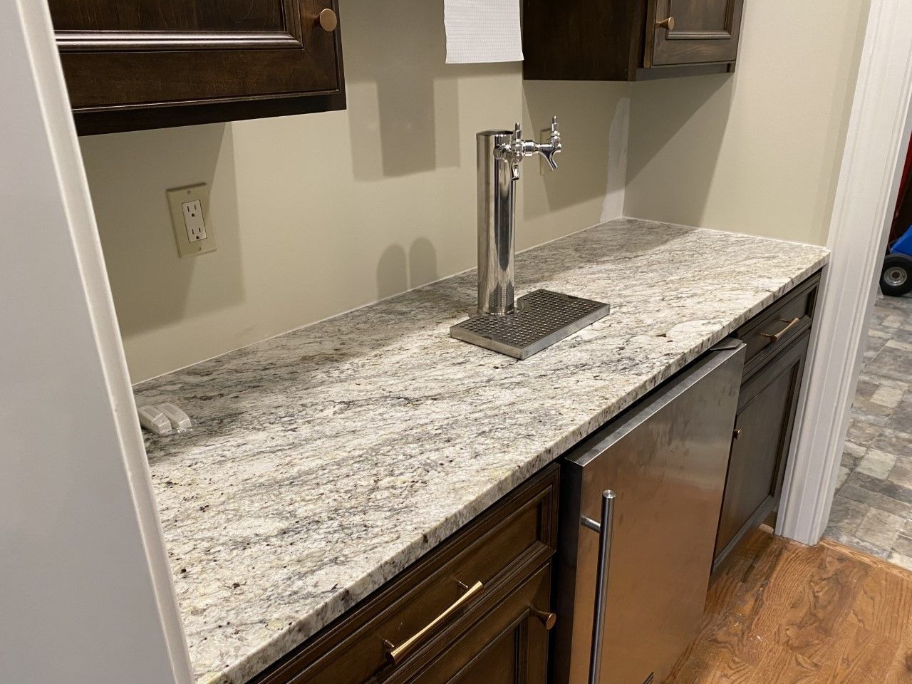 A kitchen with granite counter tops and a stainless steel refrigerator.