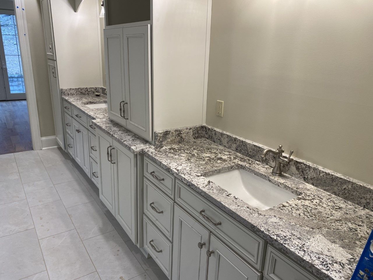 A bathroom with a sink , cabinets , and granite counter tops.
