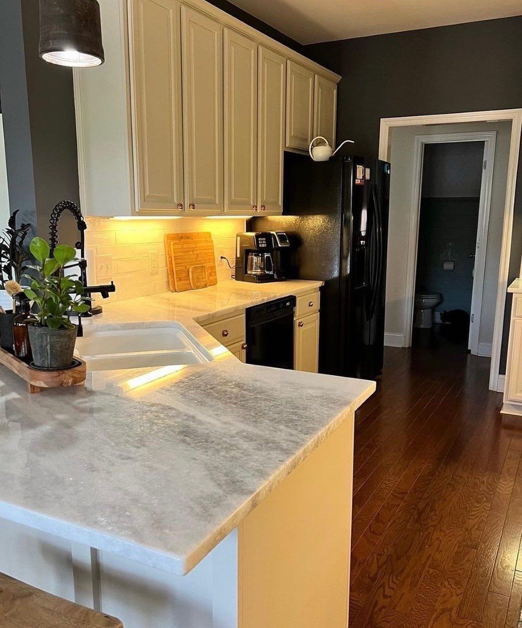 A kitchen with white cabinets and a marble counter top