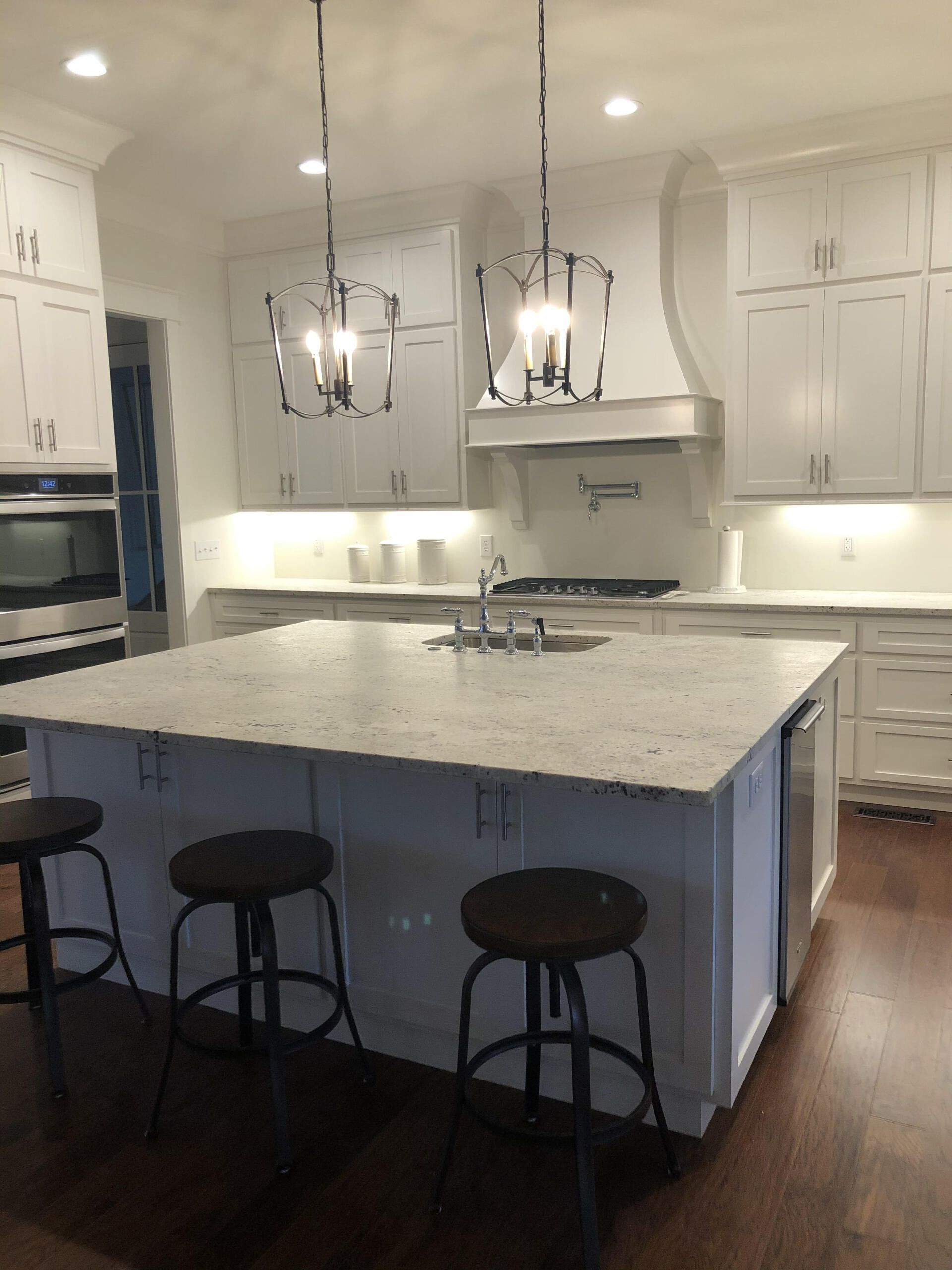 A kitchen with white cabinets and a large island