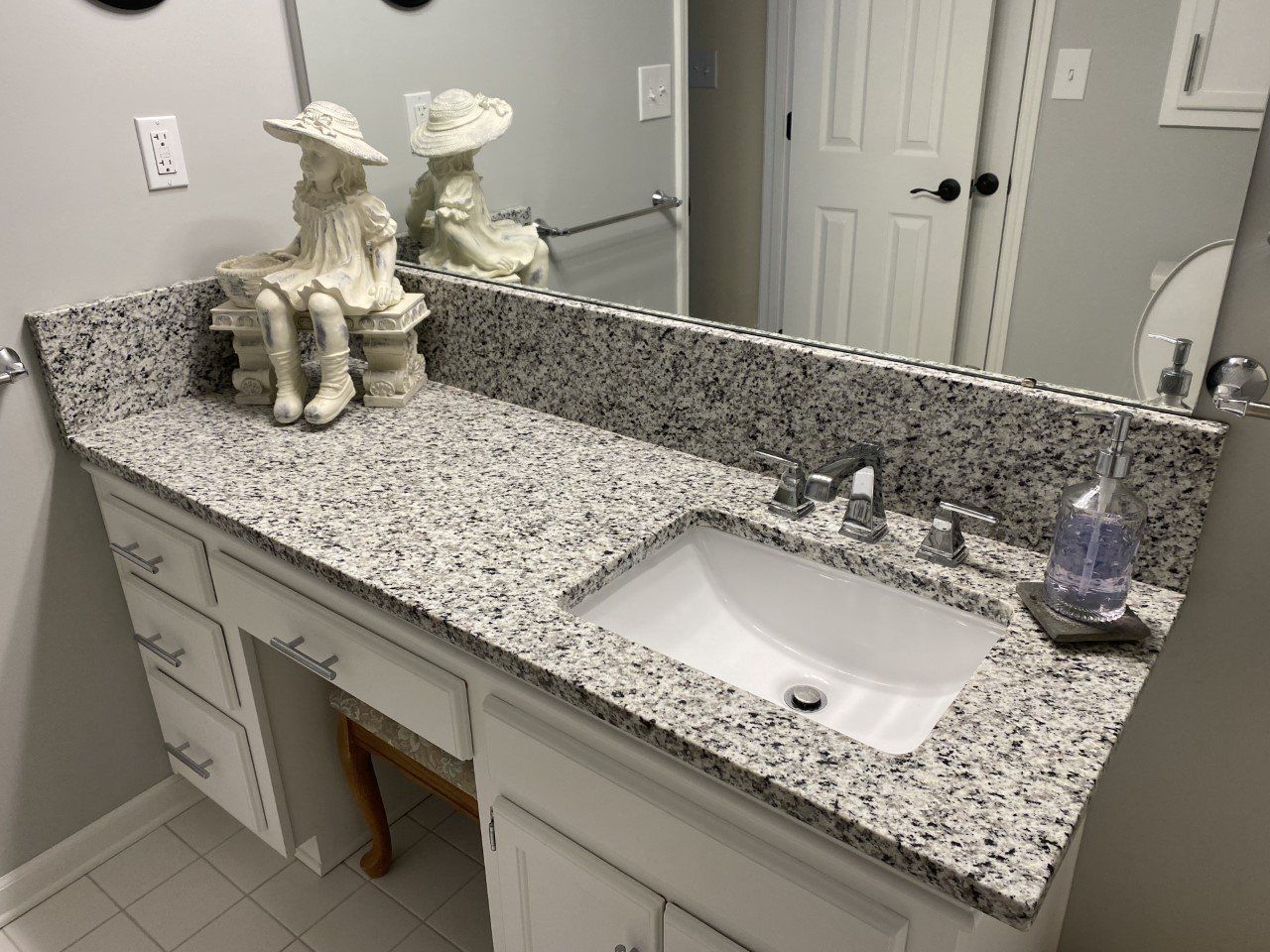 A bathroom vanity with a sink and a mirror.