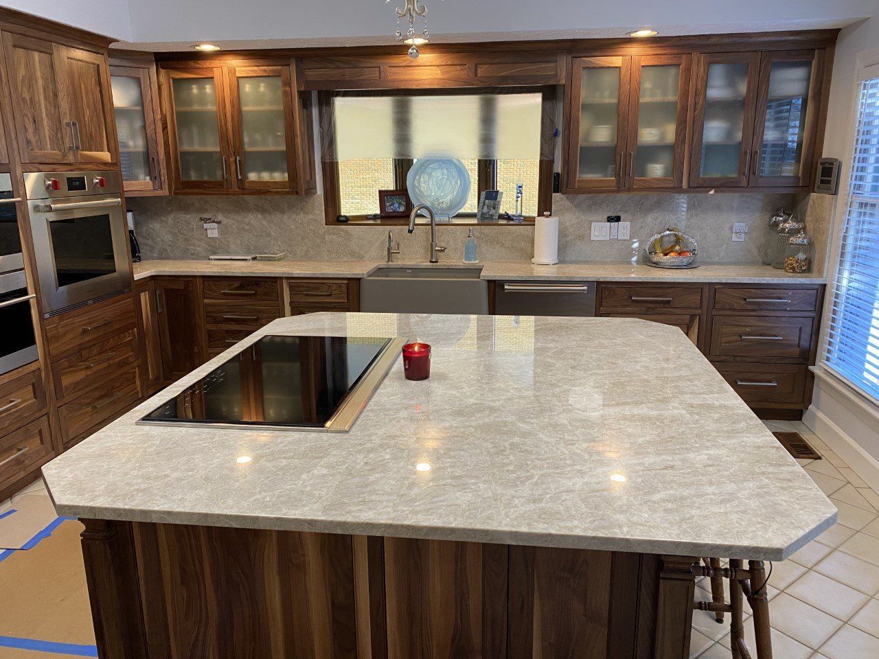 A kitchen with a large island and a stove top oven.