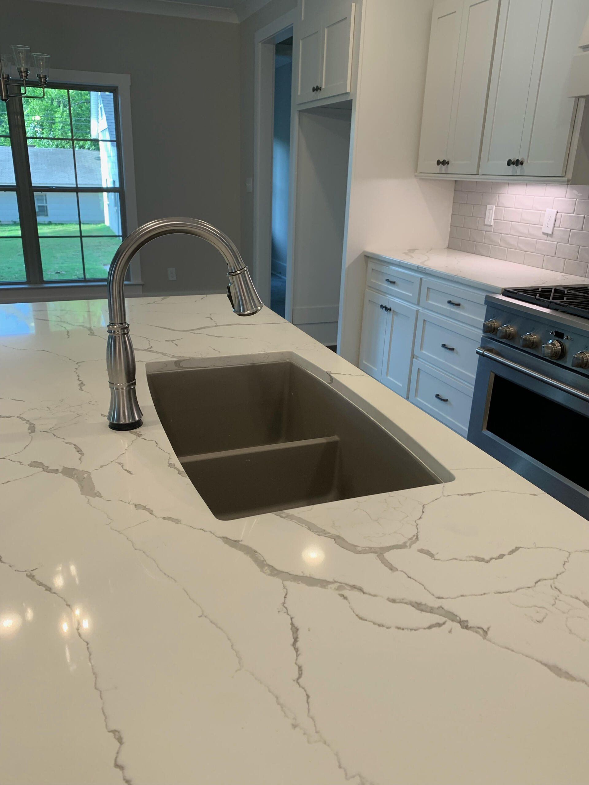 A kitchen with a sink and a stove top oven