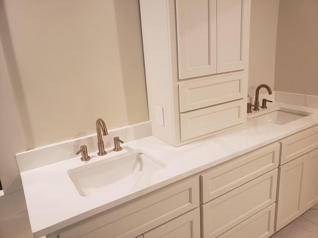 A bathroom with a sink , mirror and cabinets.