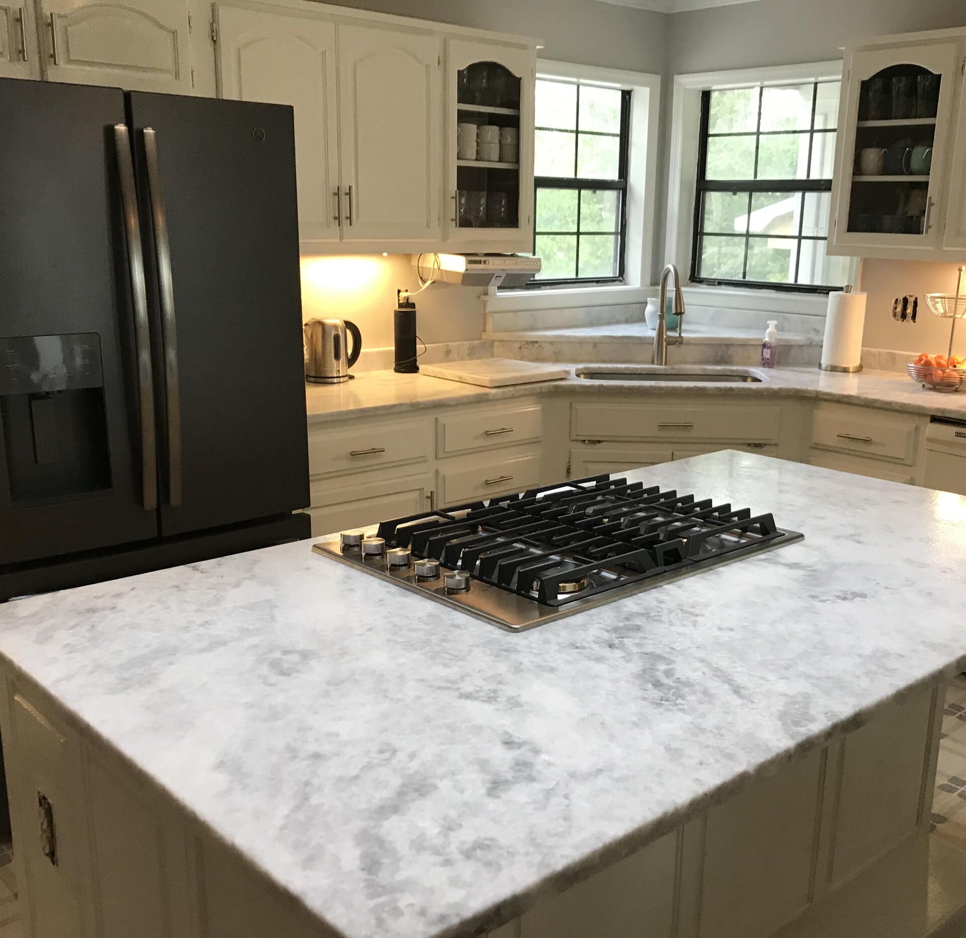 A kitchen with a stove top oven and a refrigerator