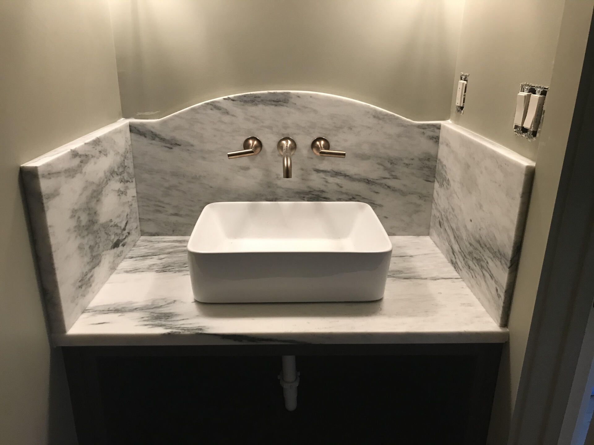 A bathroom with a sink and a marble counter top