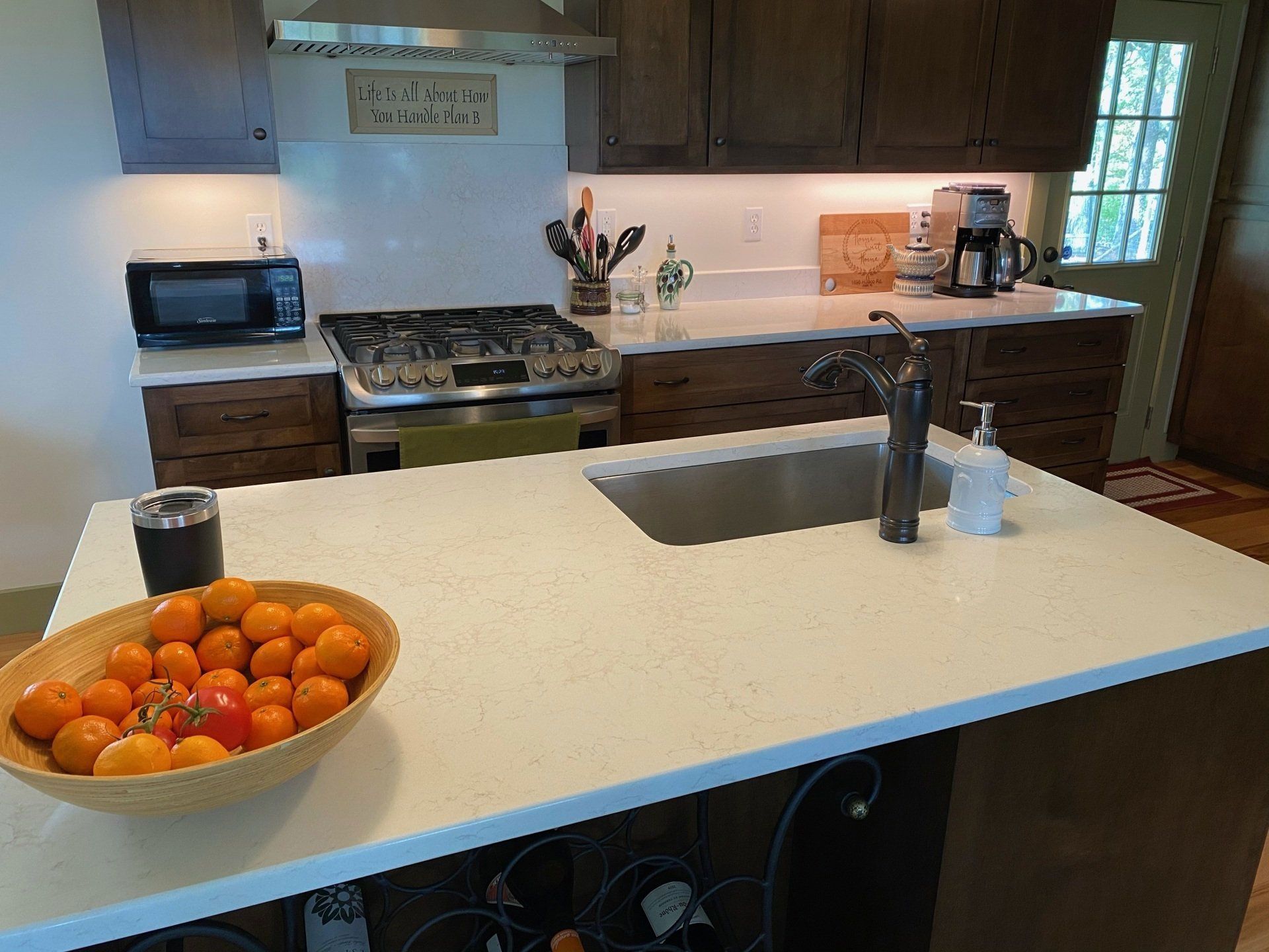 A kitchen with a bowl of oranges on the counter