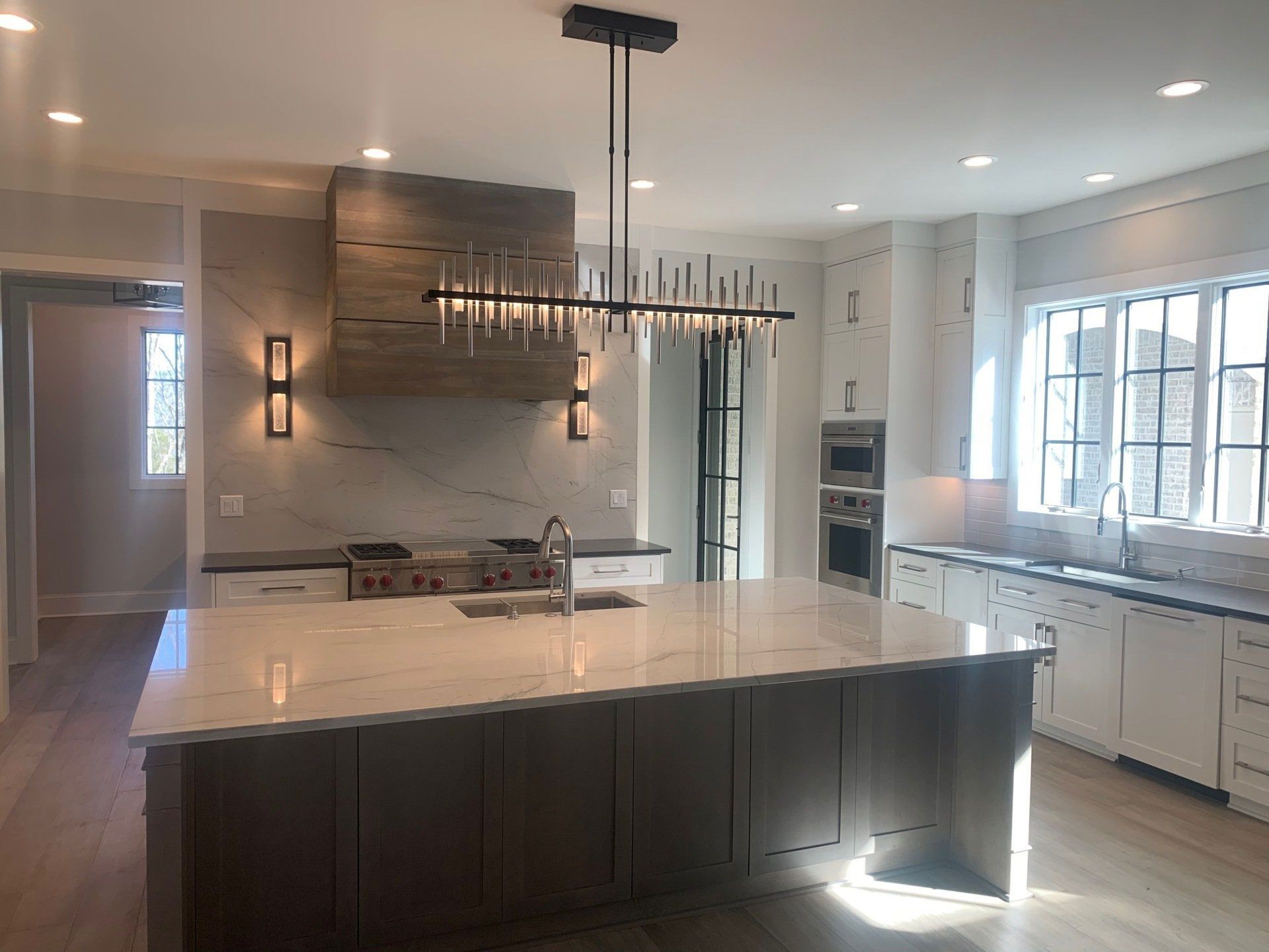 A kitchen with a large island and a chandelier hanging from the ceiling.