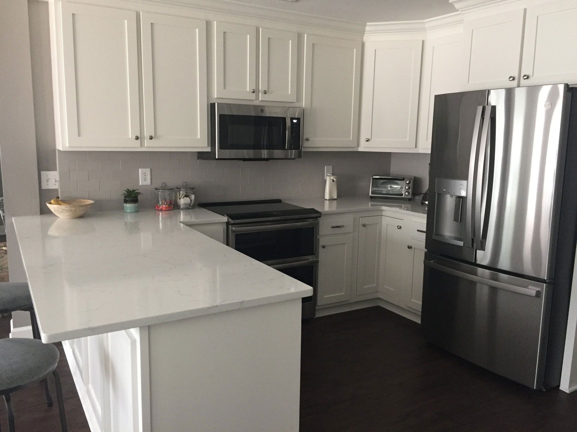 A kitchen with white cabinets and stainless steel appliances.