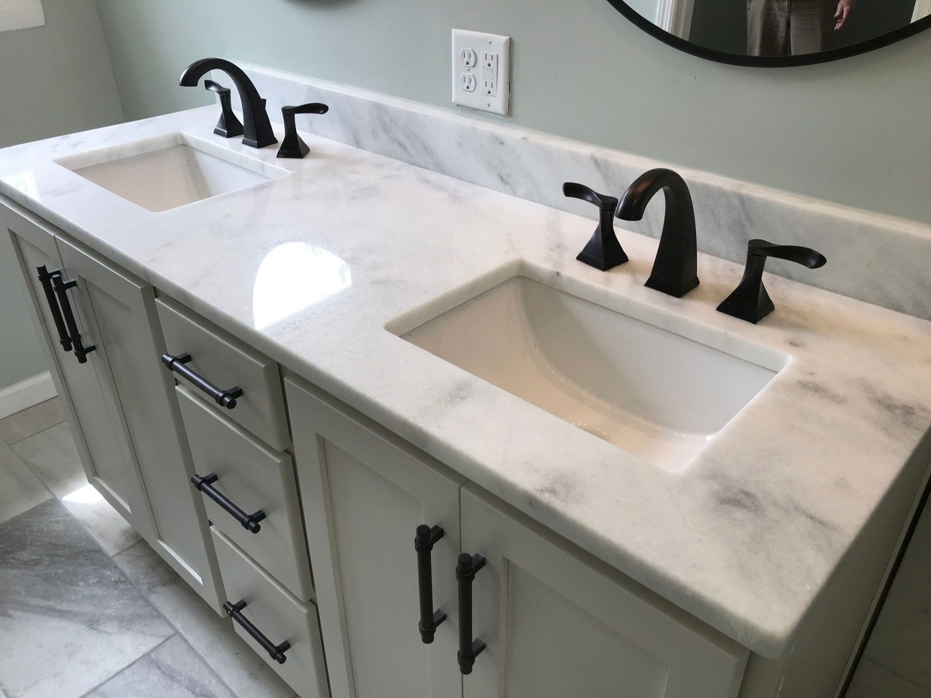 A bathroom vanity with two sinks and a mirror.