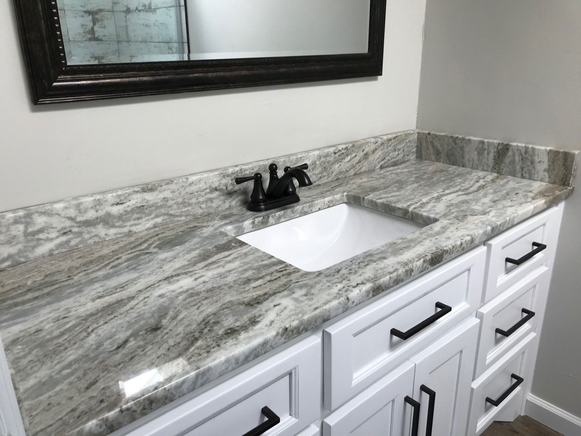 A bathroom vanity with a sink and a mirror.