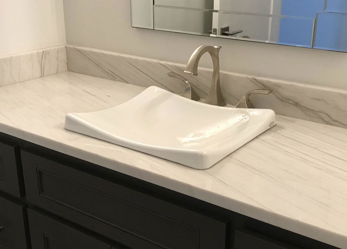 A bathroom sink with a faucet and a mirror.