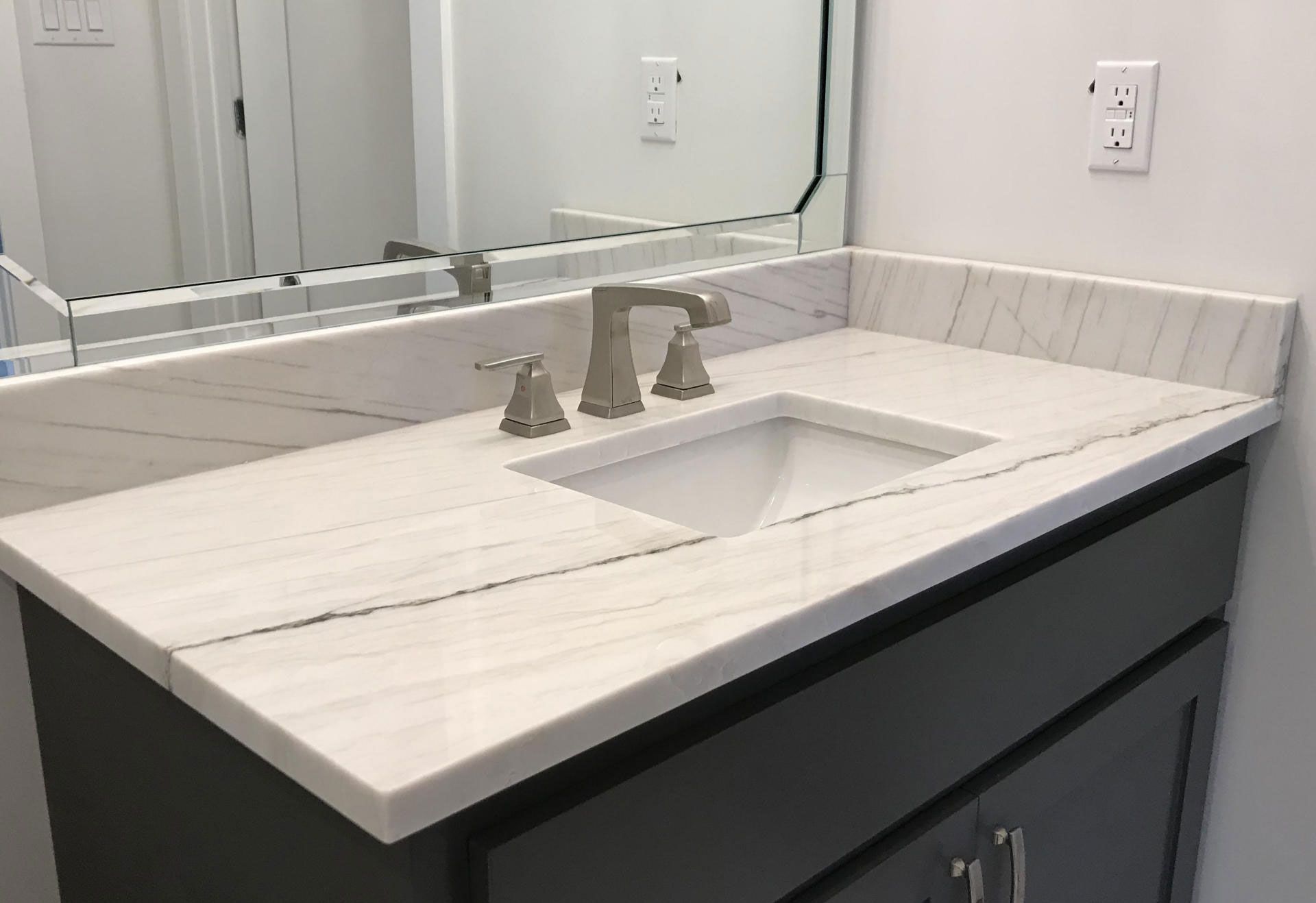 A bathroom vanity with a sink and a mirror.