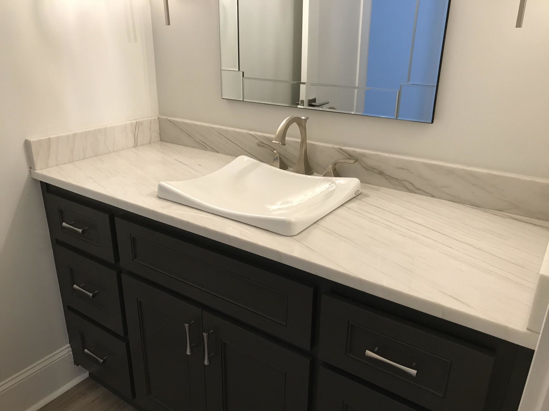 A bathroom vanity with a sink and a mirror.