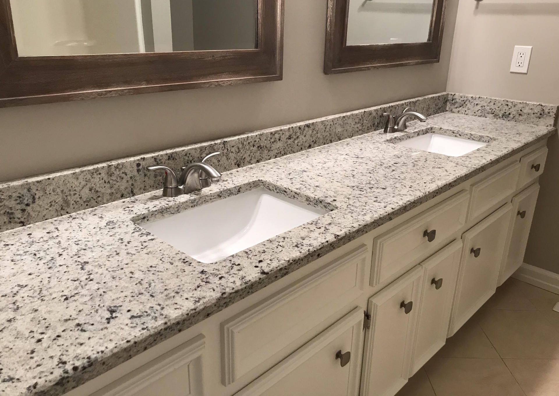 A bathroom with two sinks and two mirrors