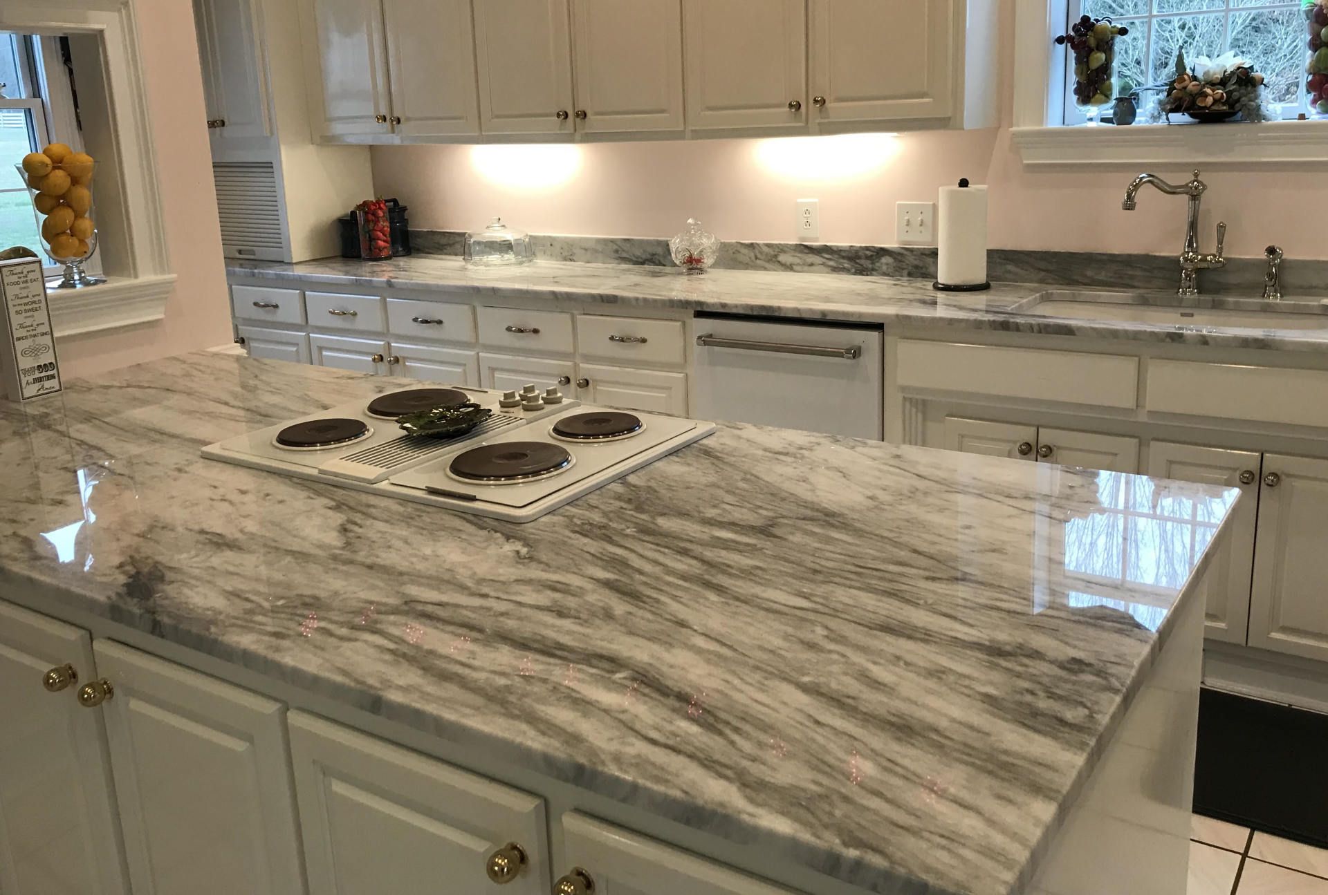 A kitchen with a large island and a stove top oven.