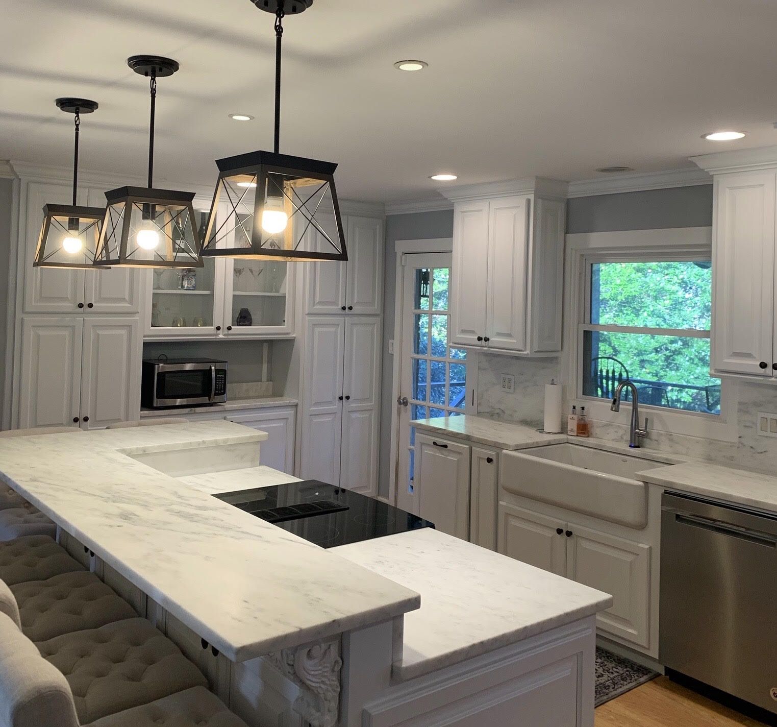 A kitchen with white cabinets and stainless steel appliances
