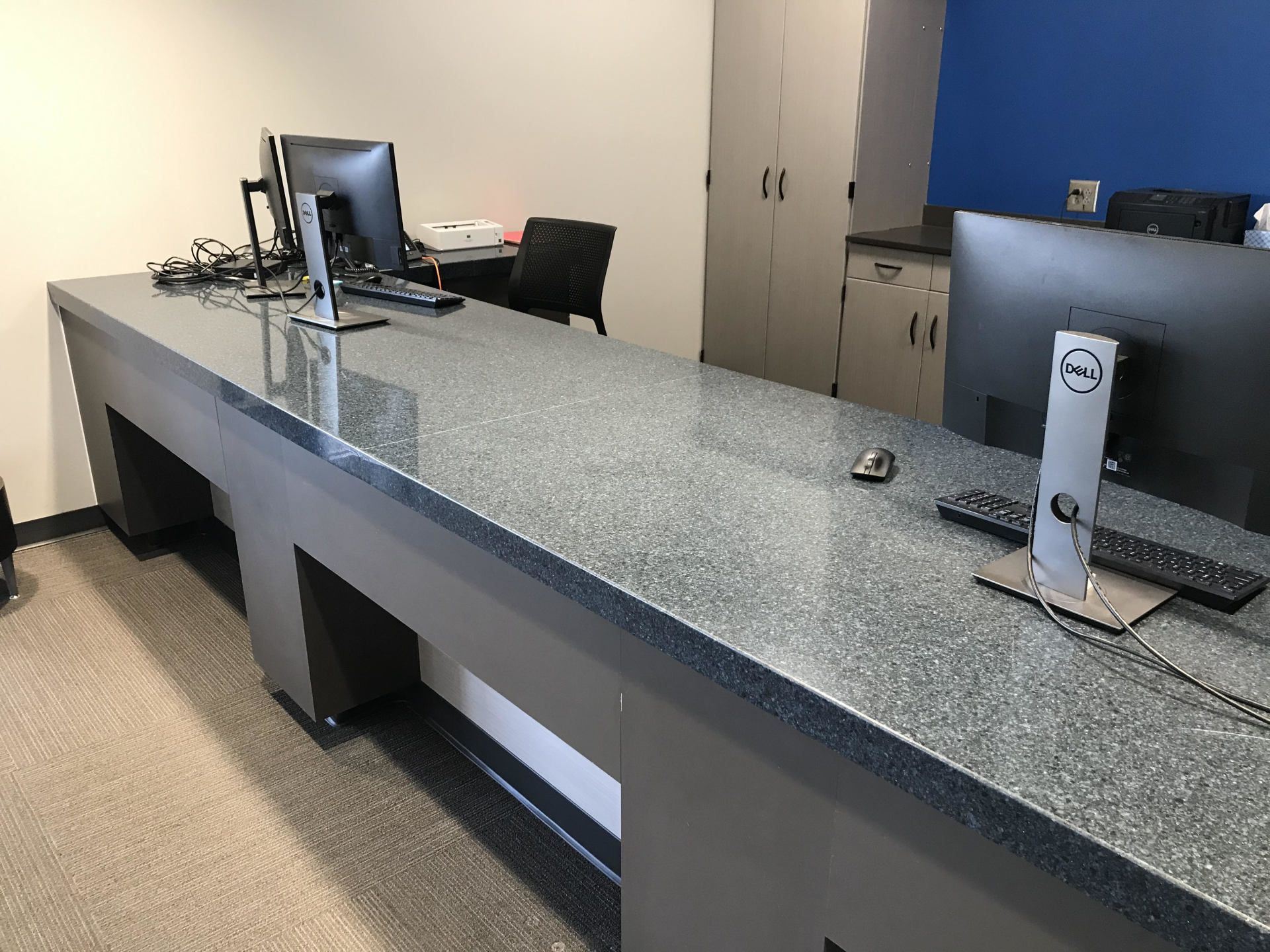 A long desk with a dell computer on top of it.