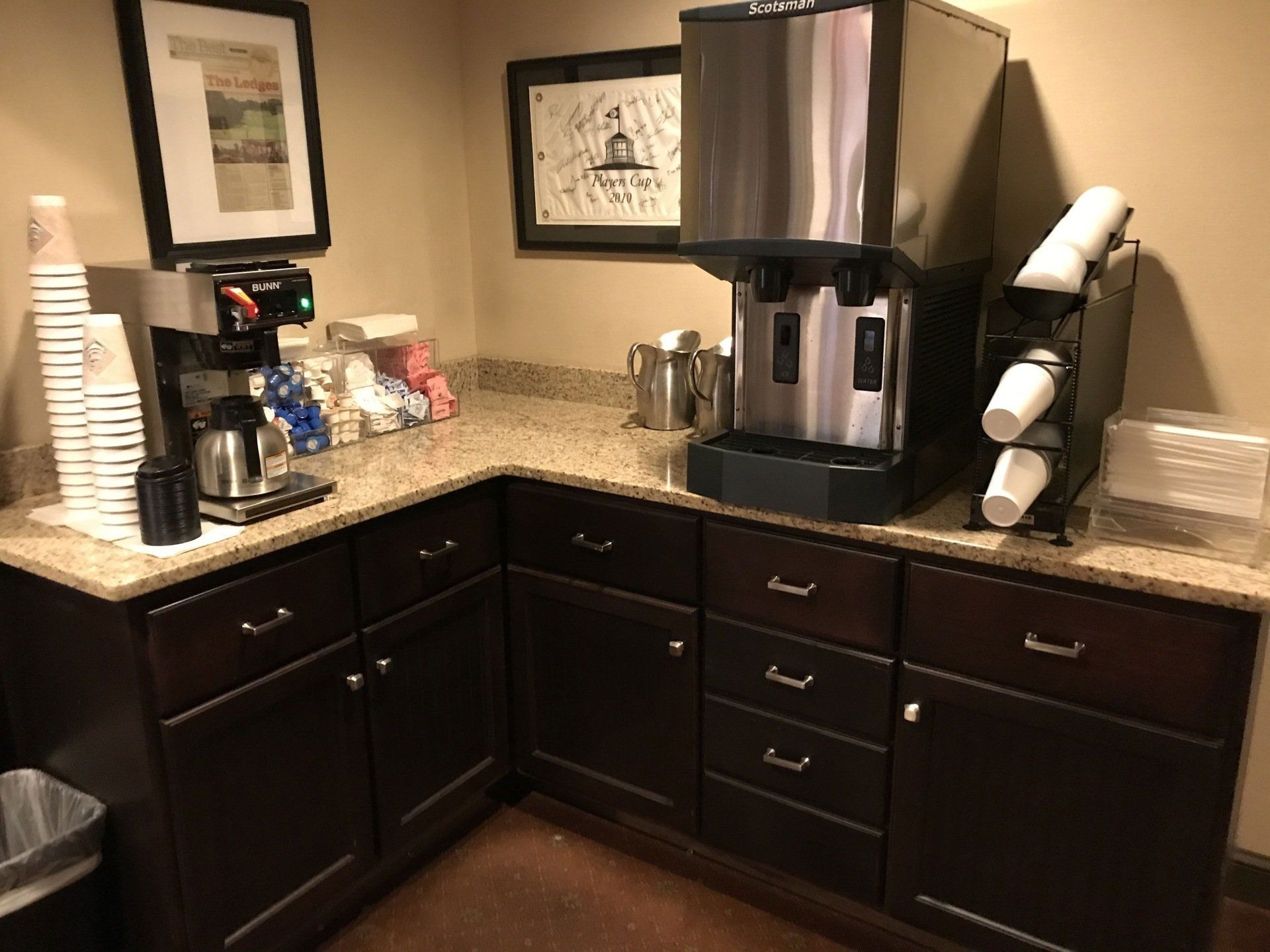 A kitchen with a coffee machine and cups on the counter