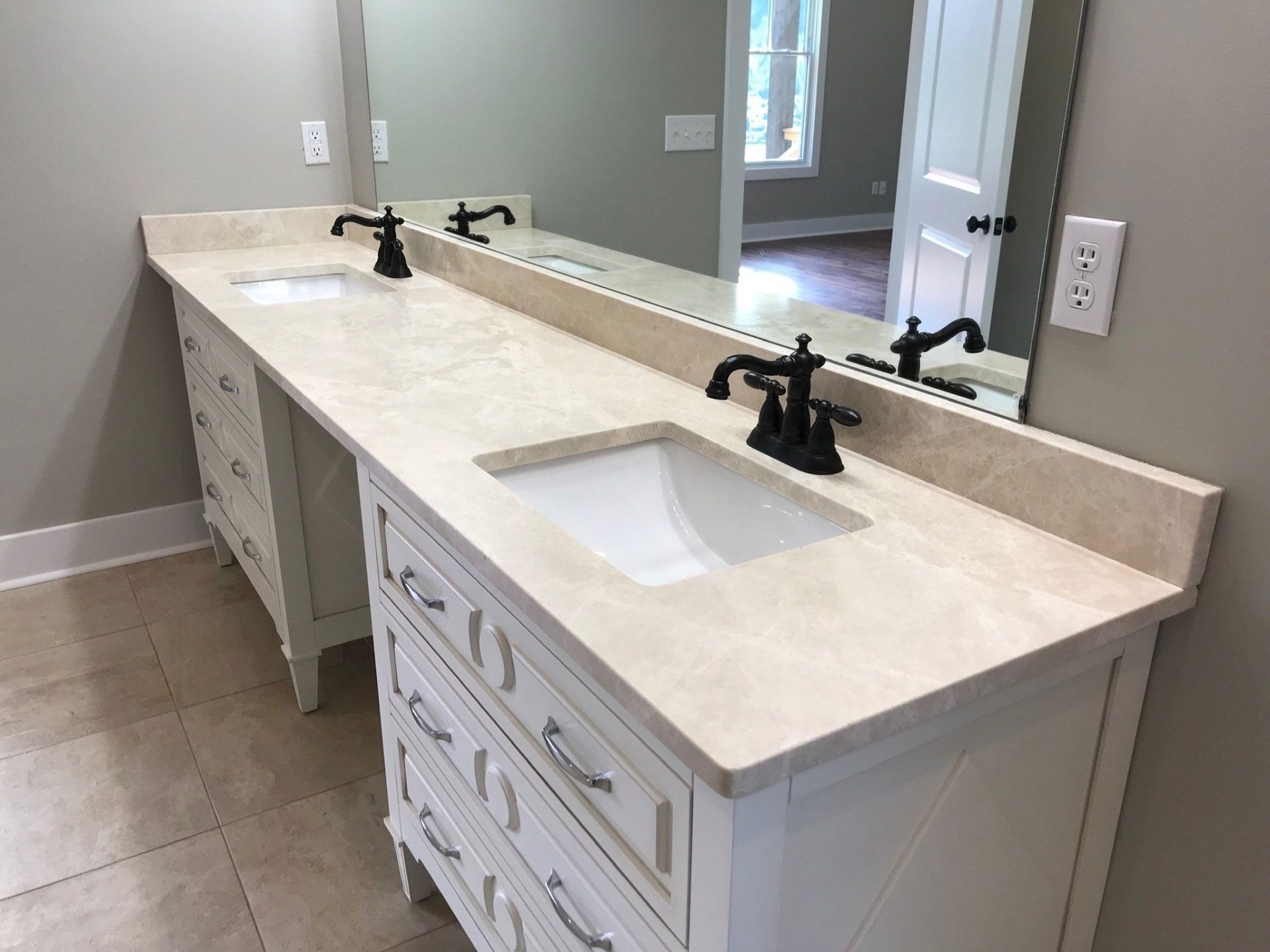 A bathroom with two sinks and a large mirror