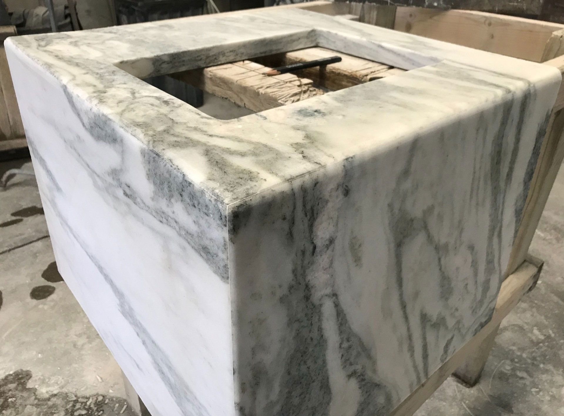A white marble counter top with a square hole in the middle.