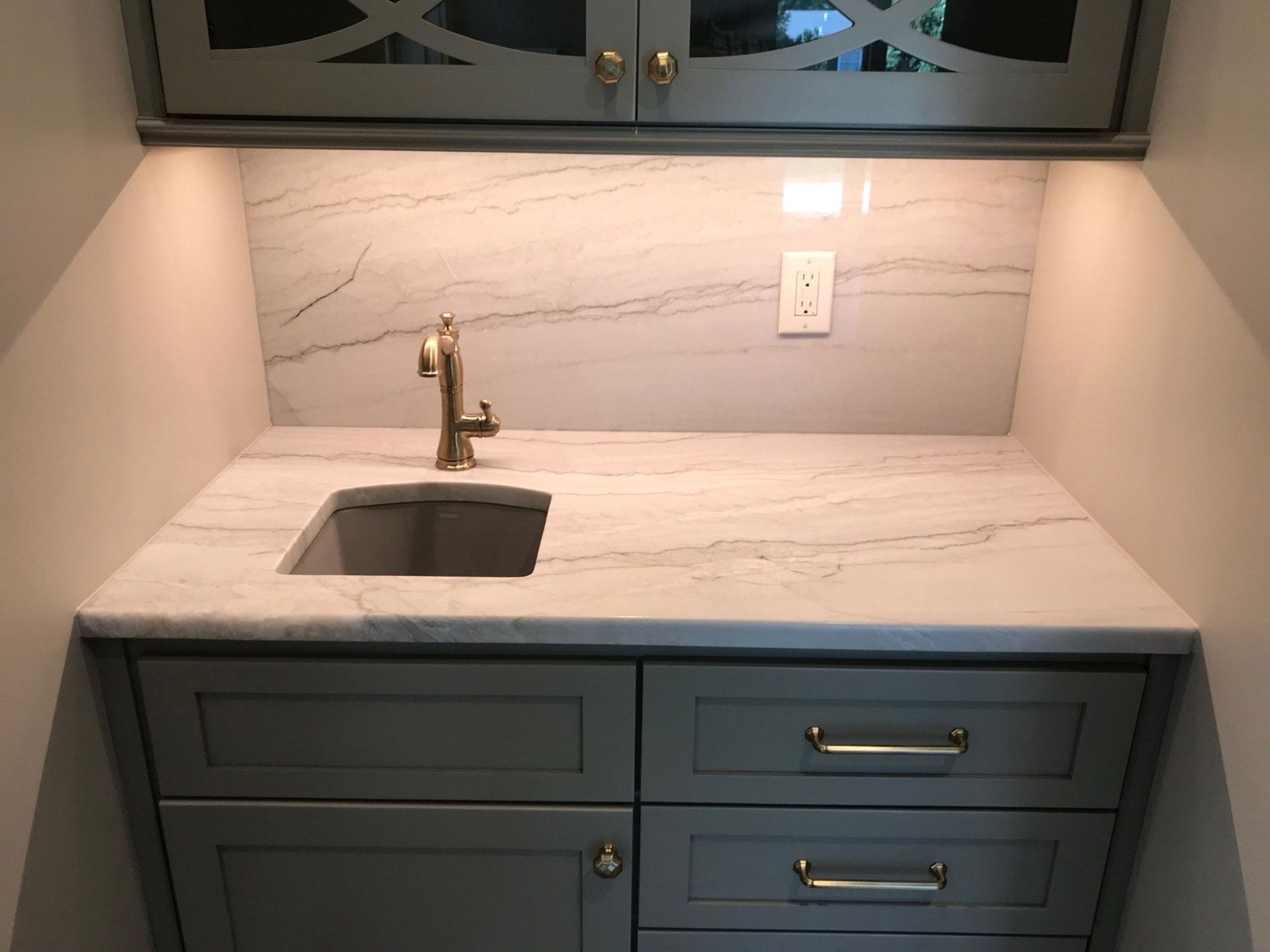 A kitchen counter with a sink and a faucet
