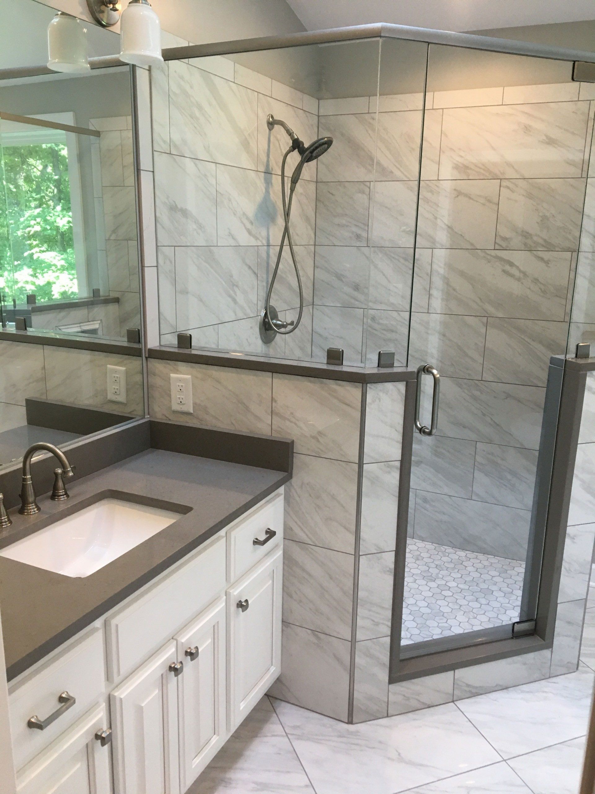A bathroom with a sink and a walk in shower
