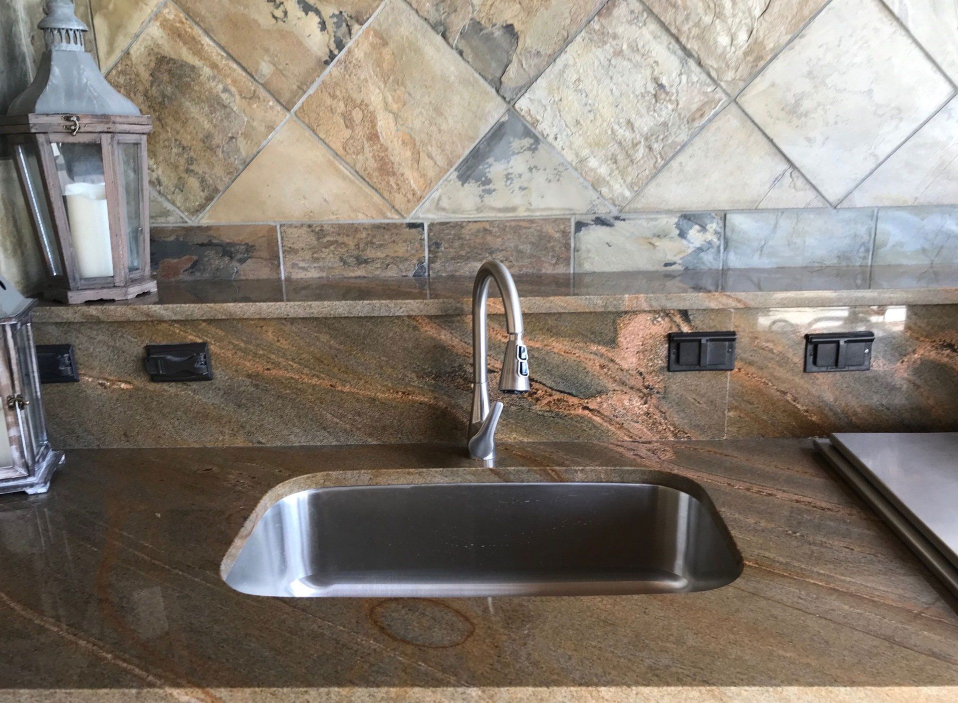 A stainless steel sink on a granite counter top