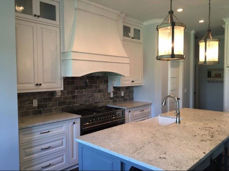 A kitchen with white cabinets and a large island