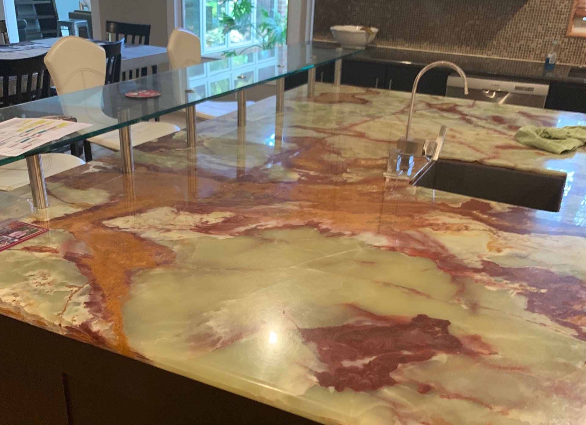 A kitchen with a marble counter top and a sink.