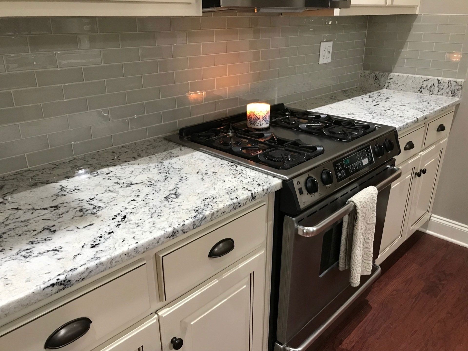 A kitchen with a stove top oven and a candle on the counter.
