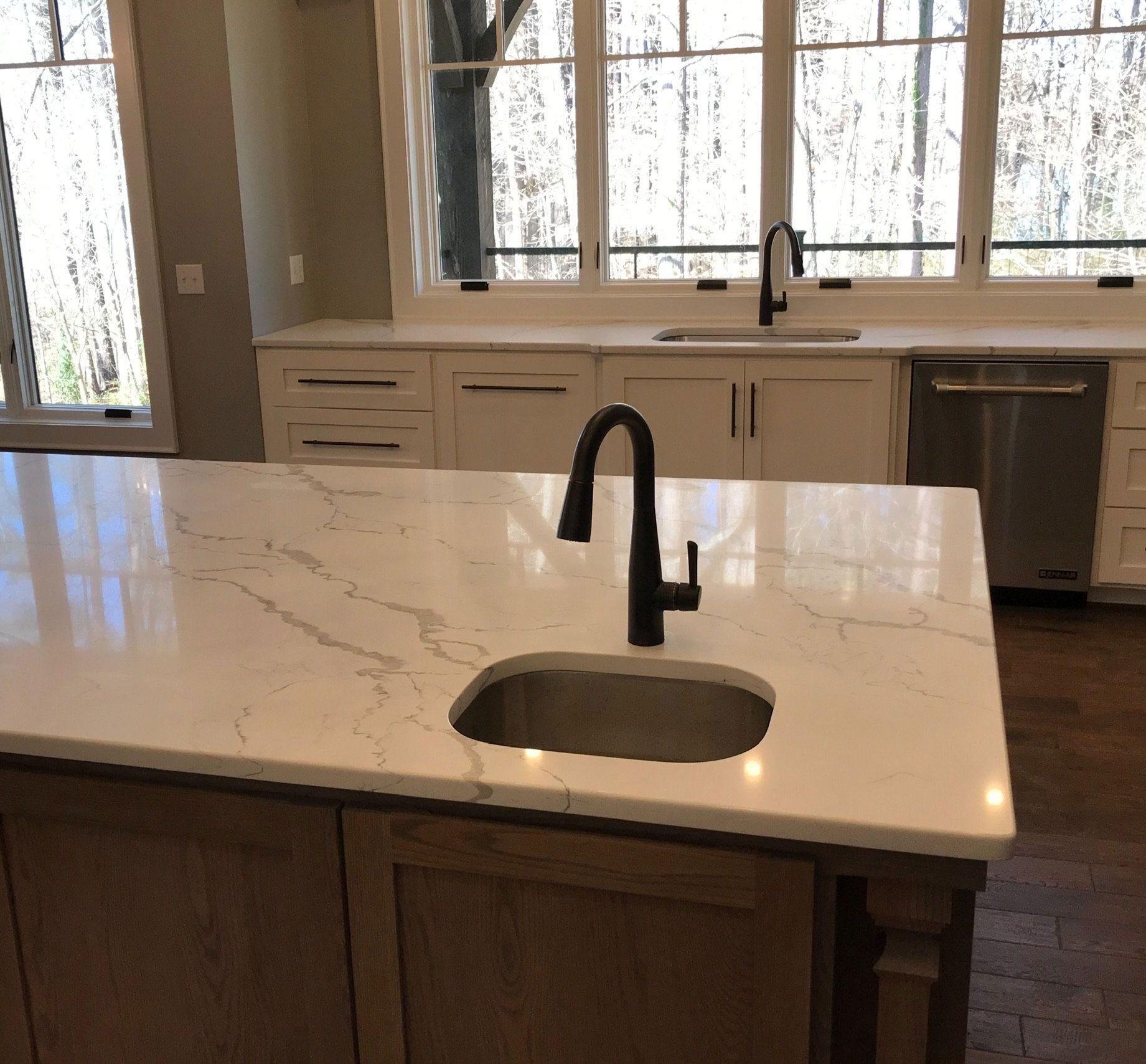 A kitchen with a marble counter top and a sink