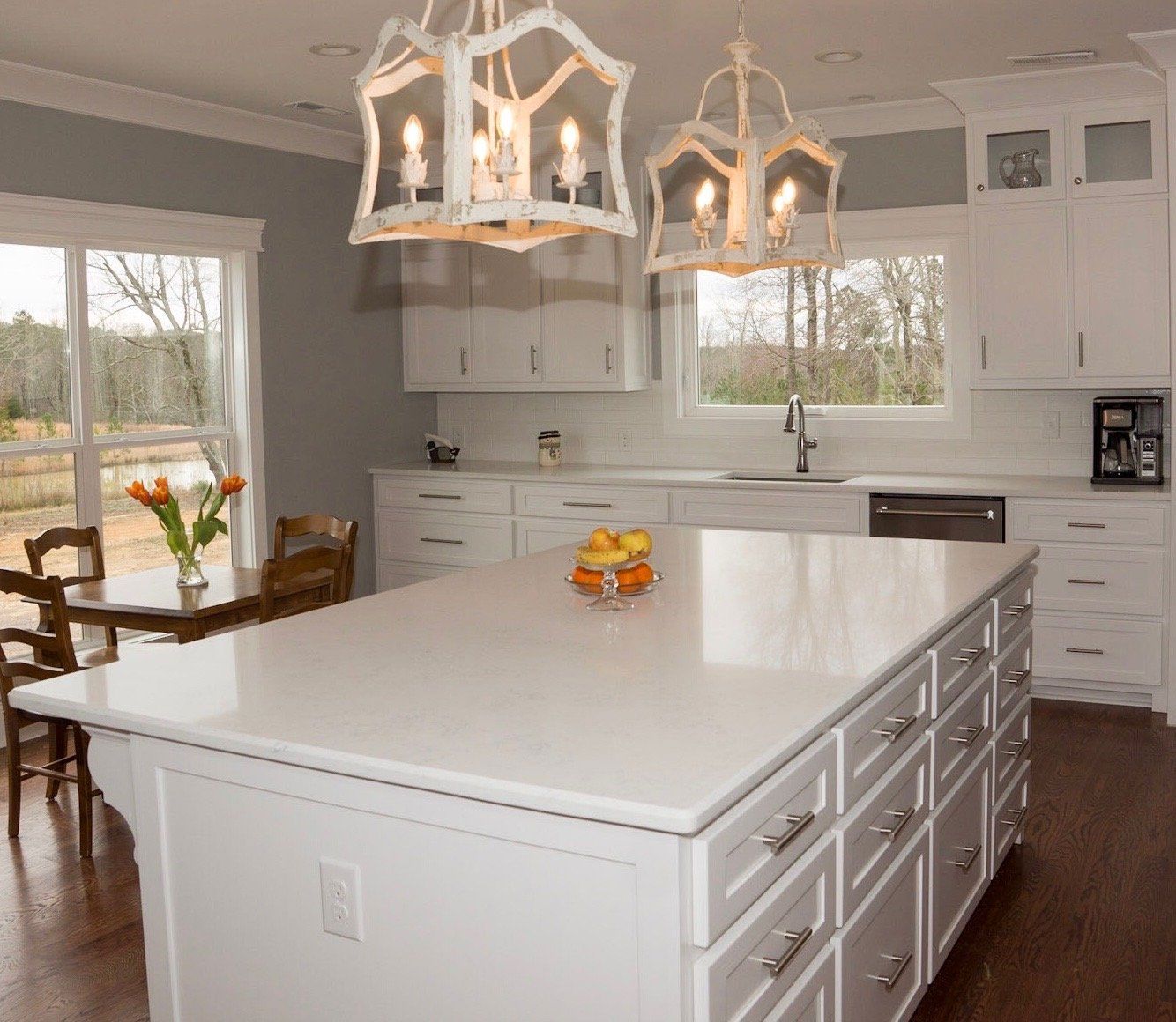 A kitchen with white cabinets and a large island
