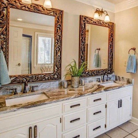 A bathroom with two sinks and two mirrors.