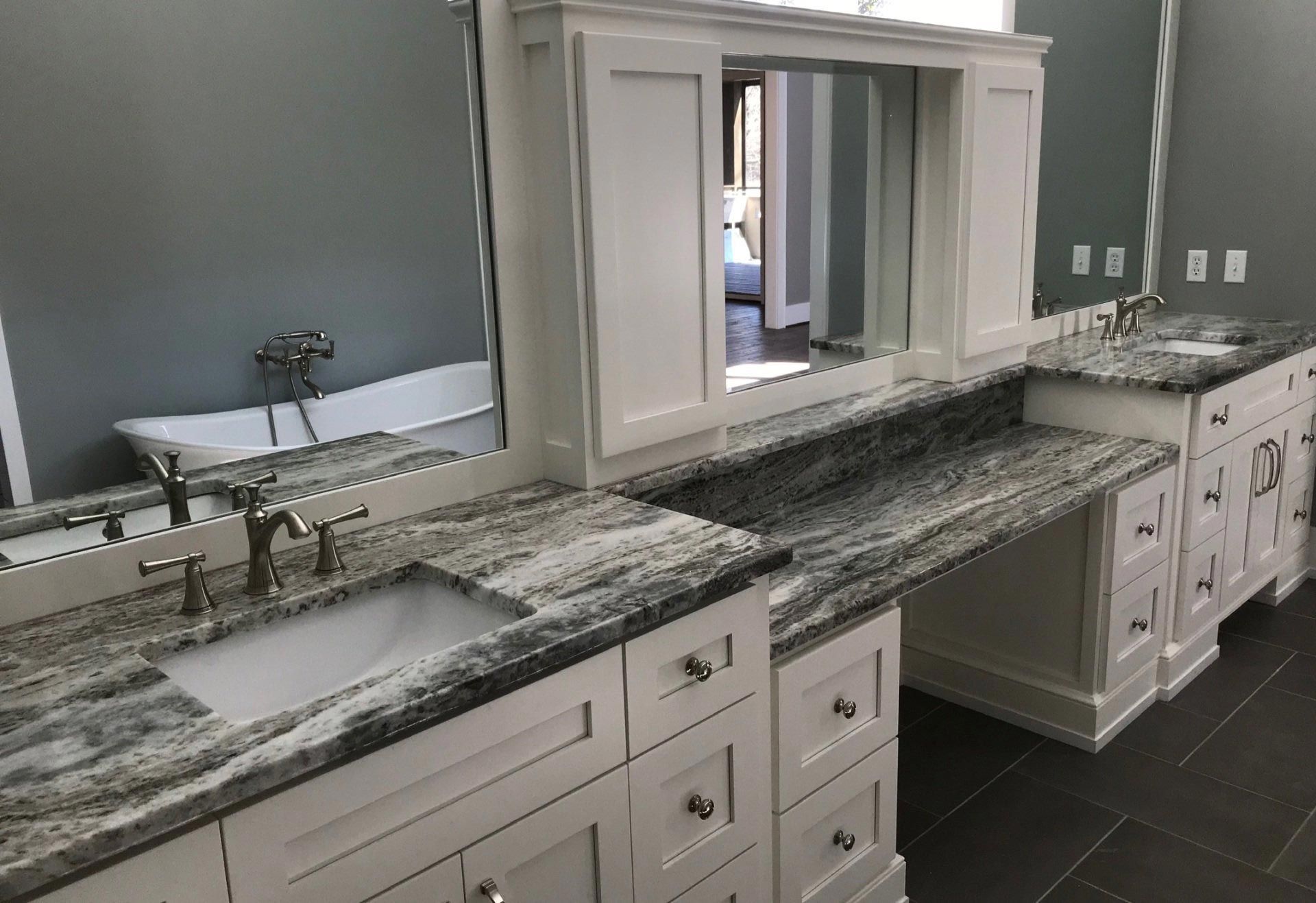 A bathroom with two sinks , two mirrors and a bathtub.