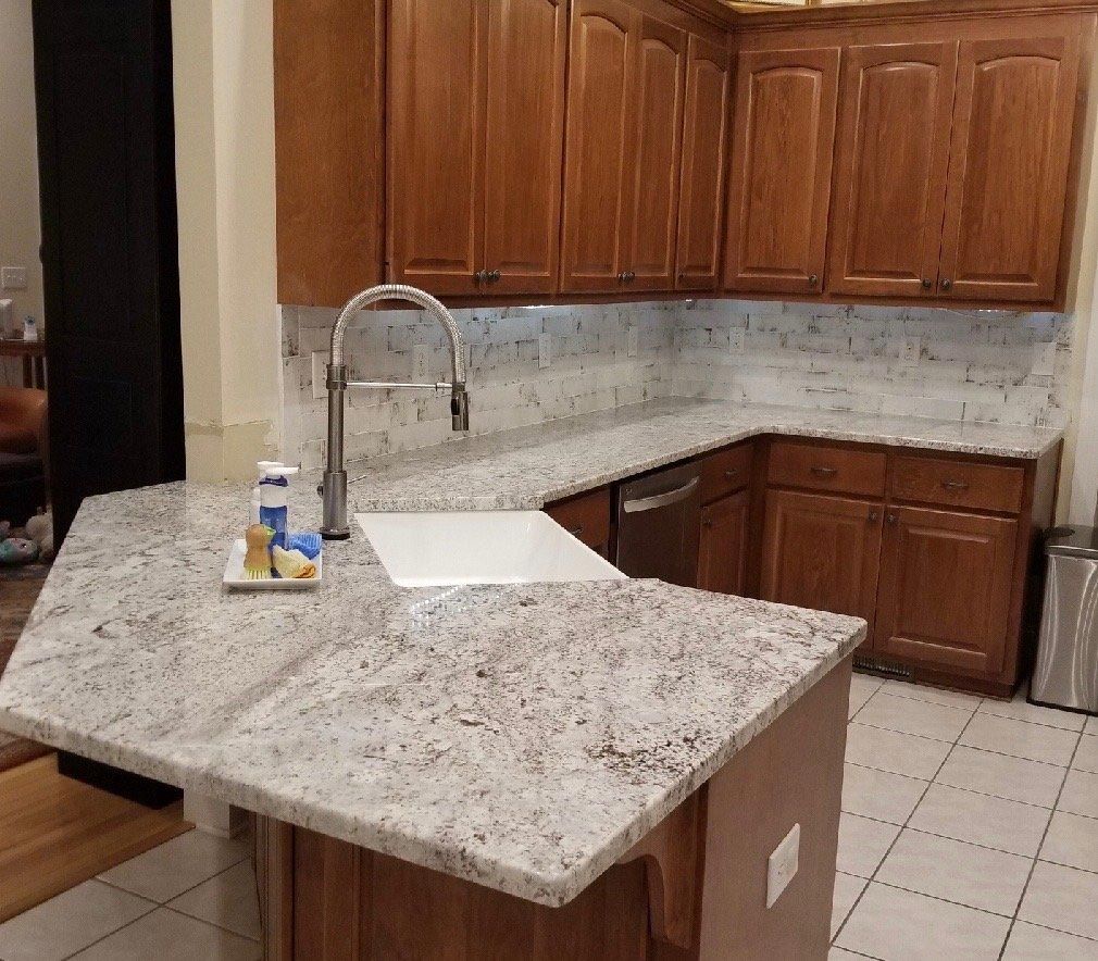 A kitchen with granite counter tops and wooden cabinets