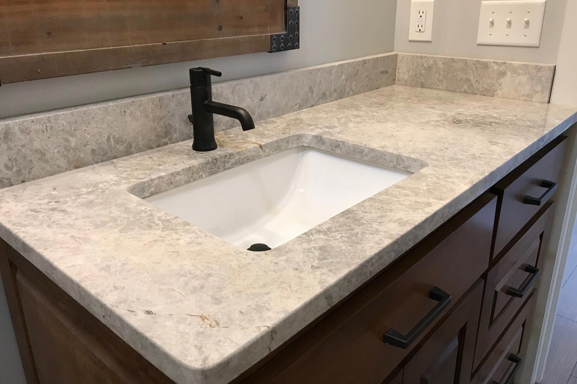 A bathroom vanity with a sink and a black faucet.