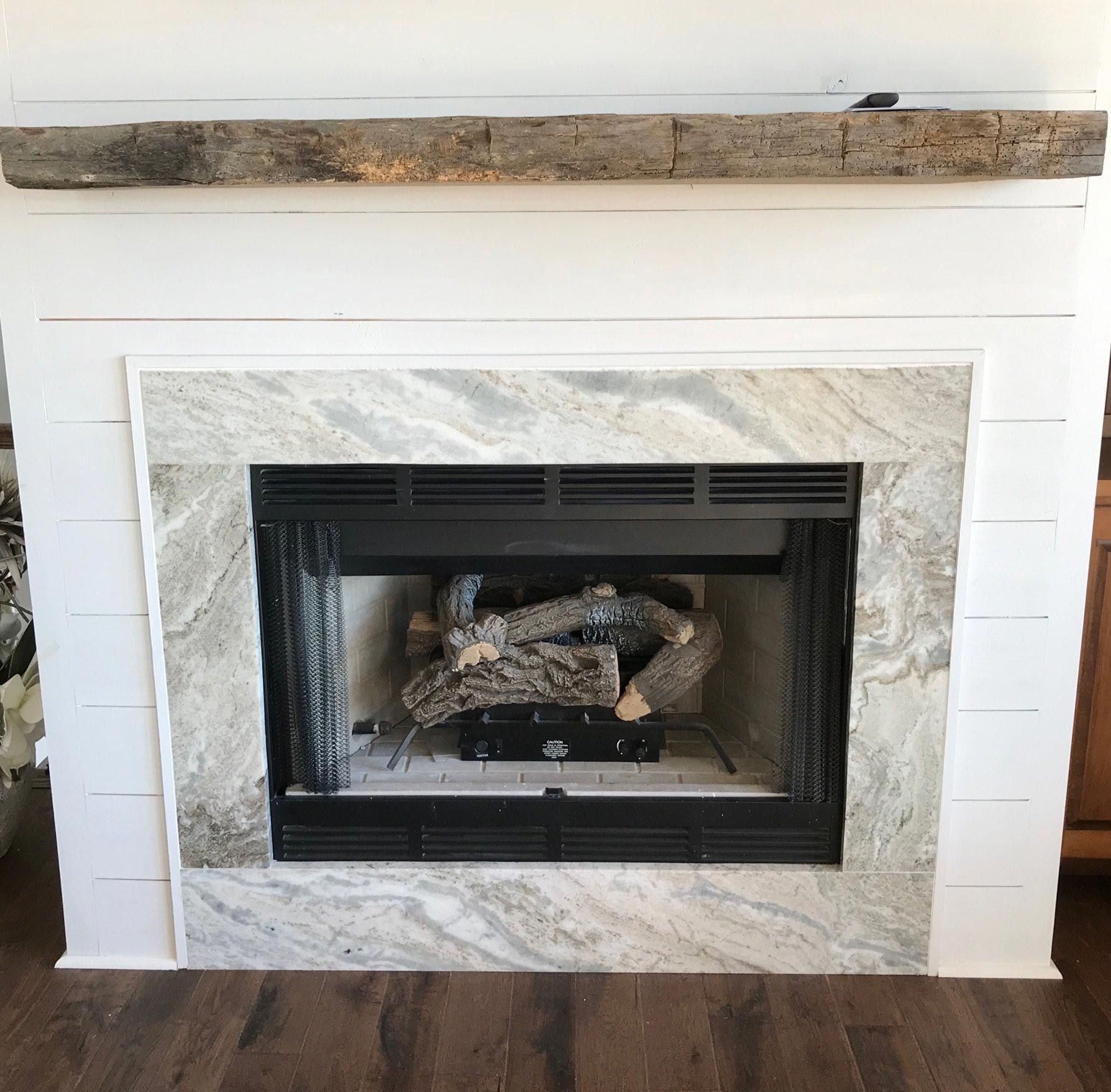 A fireplace with logs in it and a wooden mantle