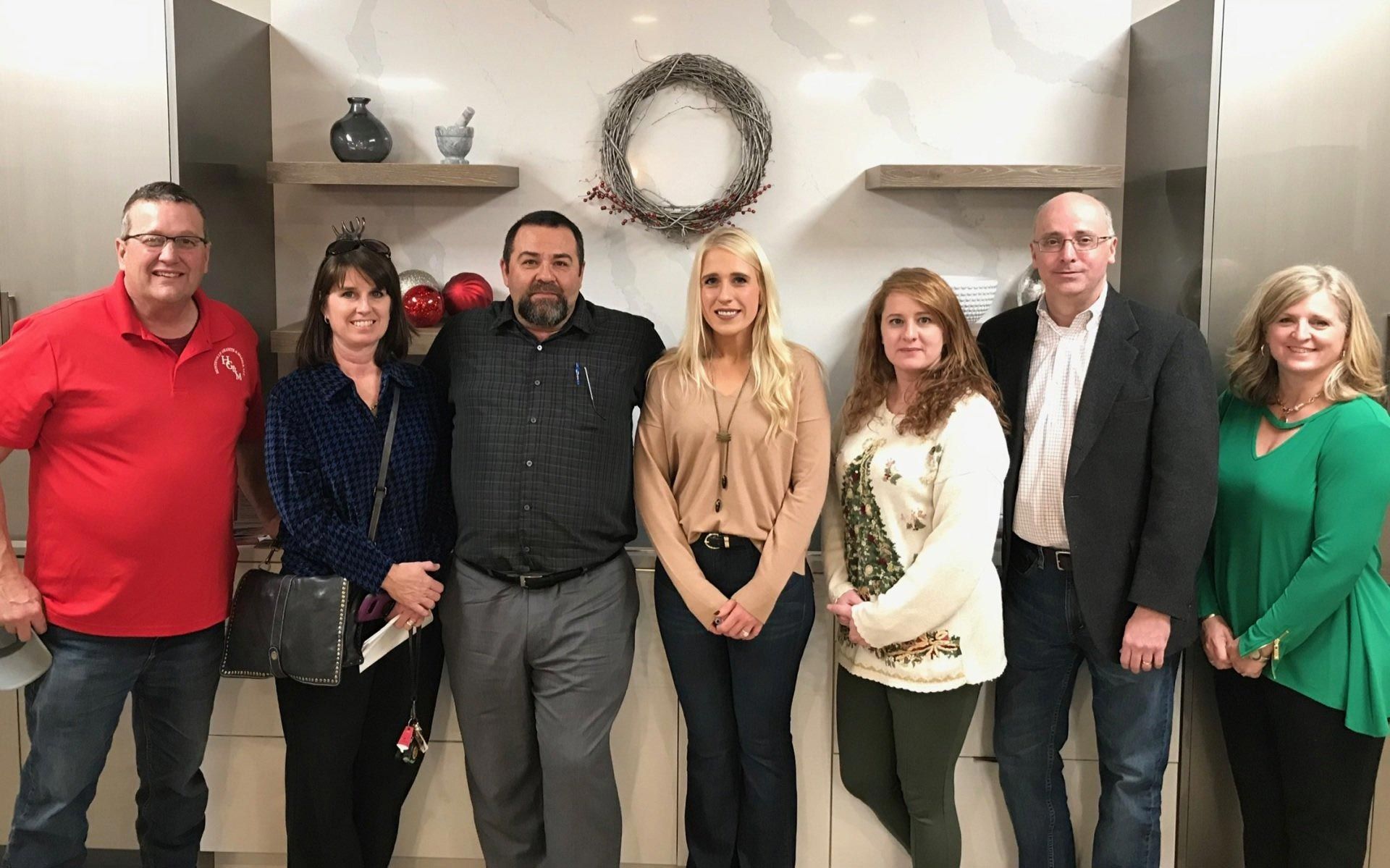 A group of people are posing for a picture in a kitchen.