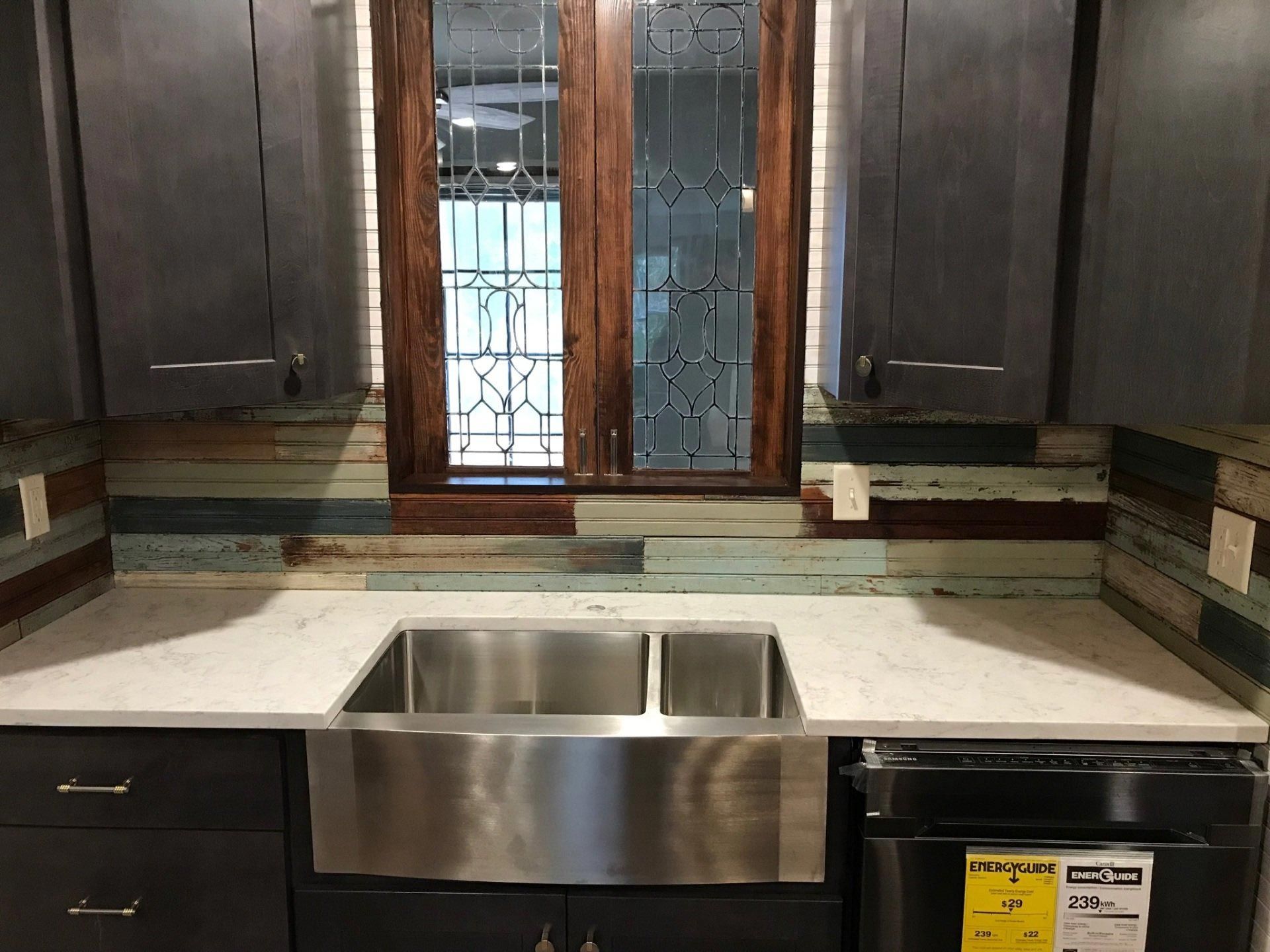 A kitchen with a stainless steel sink and a window.