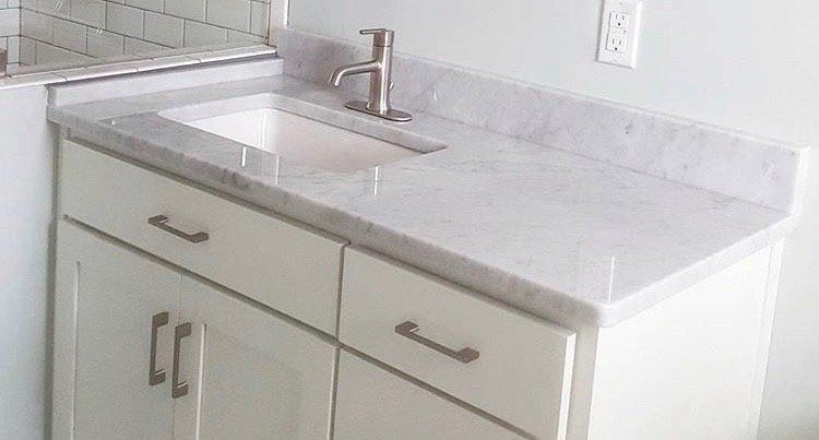 A bathroom vanity with a sink and a faucet.