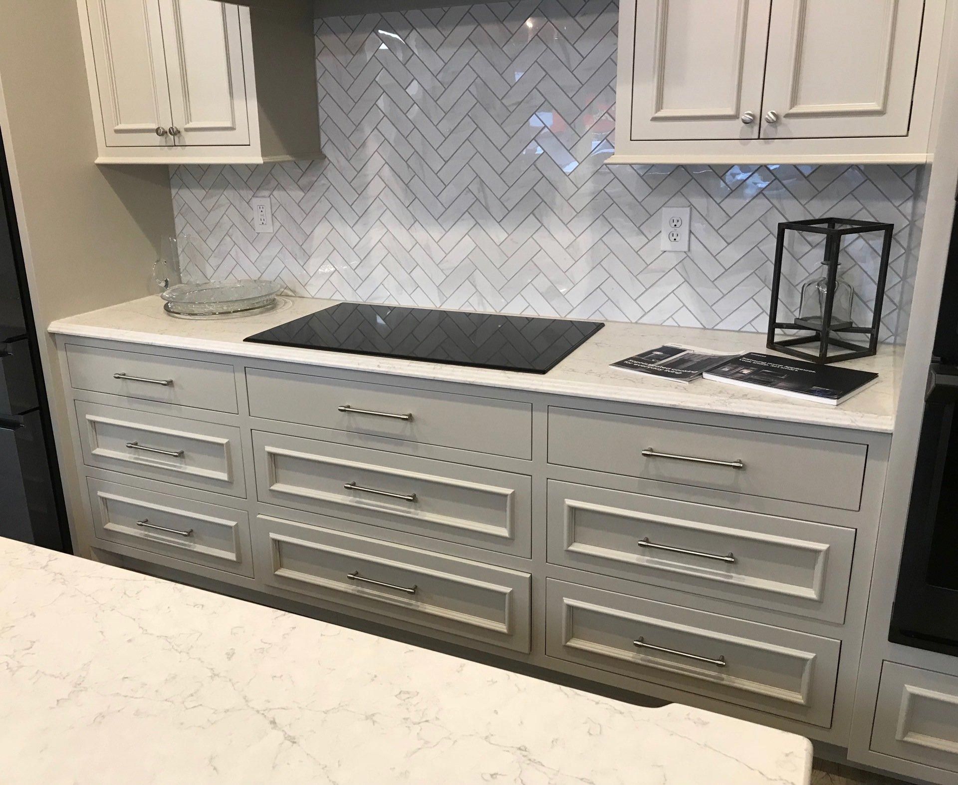 A kitchen with white cabinets and a stove top oven.