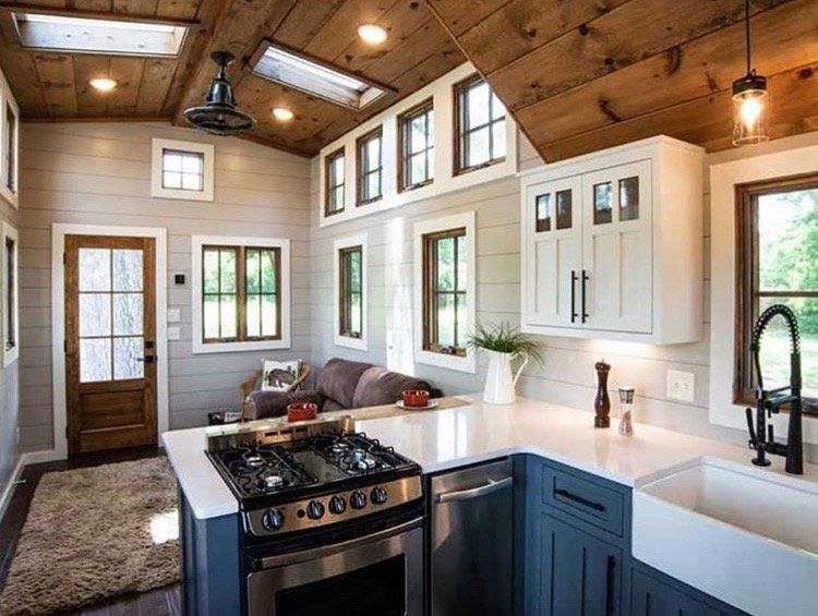 A kitchen in a small house with a stove , sink , and cabinets.