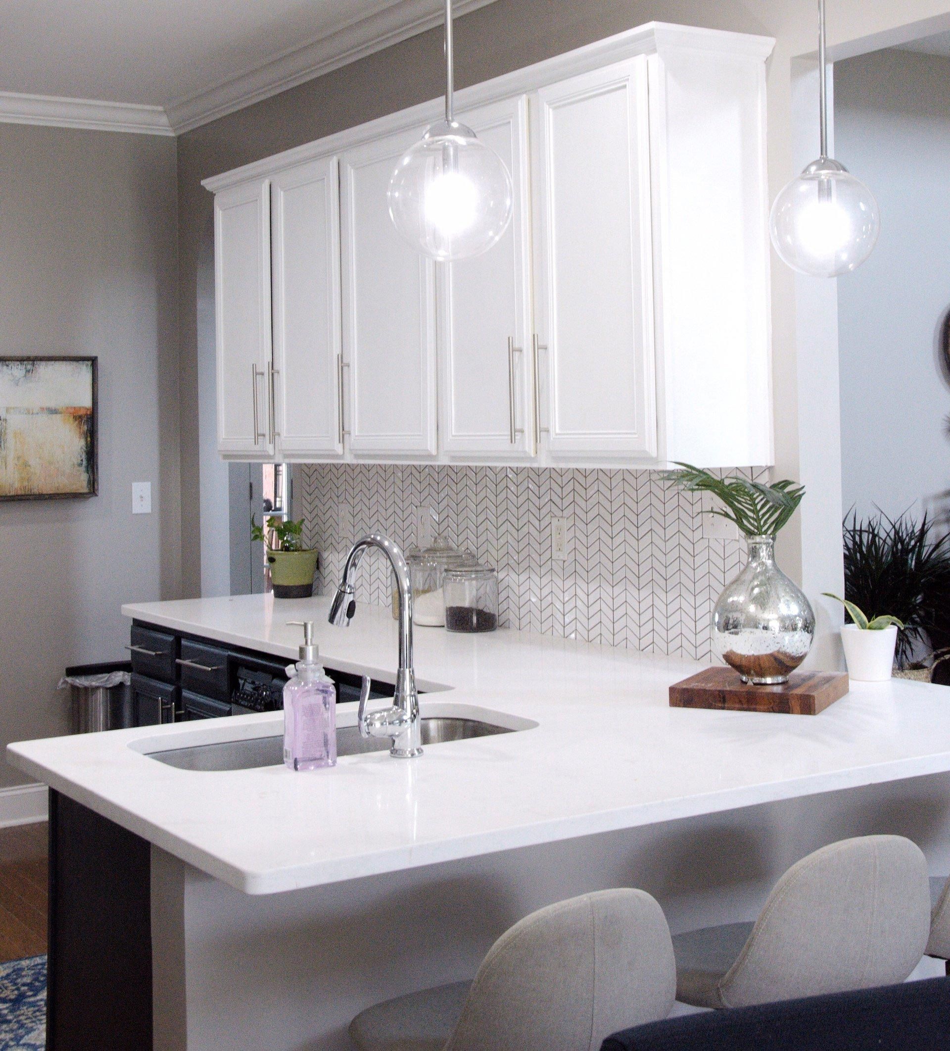 A kitchen with white cabinets and a sink