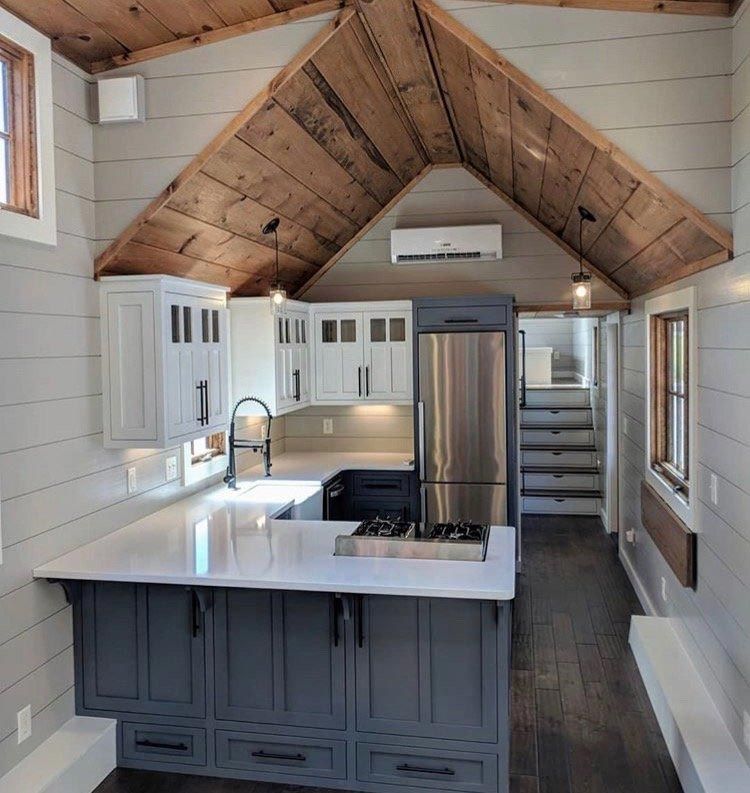 A kitchen with gray cabinets and a stainless steel refrigerator